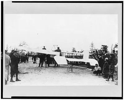 [Louis Blériot(?) on his airplane, surrounded by people]