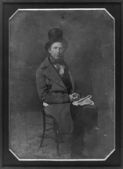 [Horace Greeley, full-length portrait, three-quarters to the right, seated in chair, wearing tall hat, folded newspaper in lap, carpet on floor]