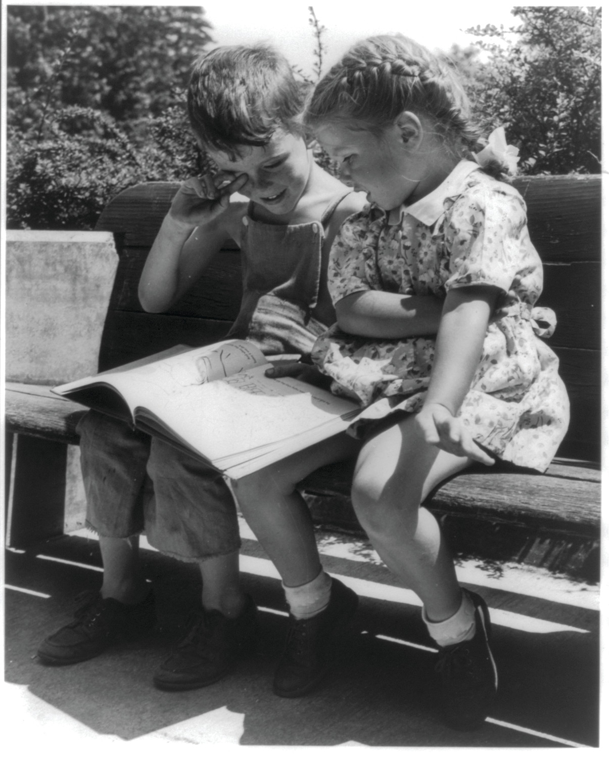 [Boy and girl on bench looking at book, Greenbelt, Maryland], 1946 July. — historic photograph