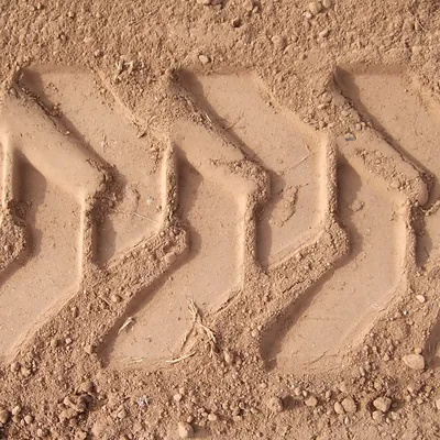 Tire tread marks pressed into sandy dirt