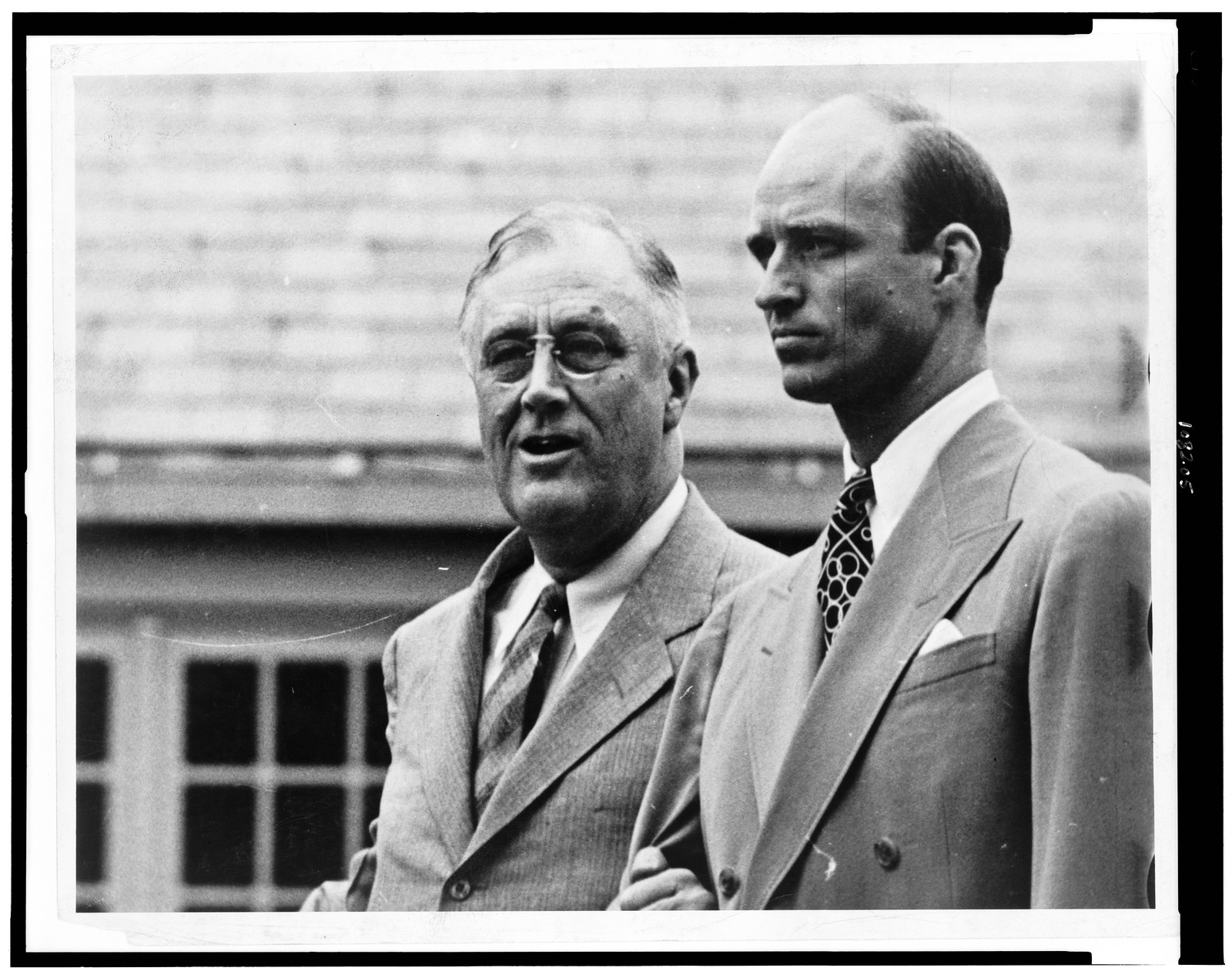 [Franklin D. Roosevelt, half-length portrait, standing, facing left, with his son, James Roosevelt], [ca. 1940] — historic photograph