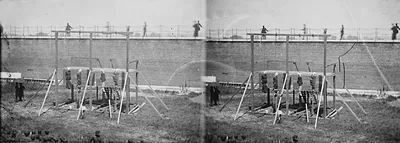 Stereo view of gallows before a brick prison wall