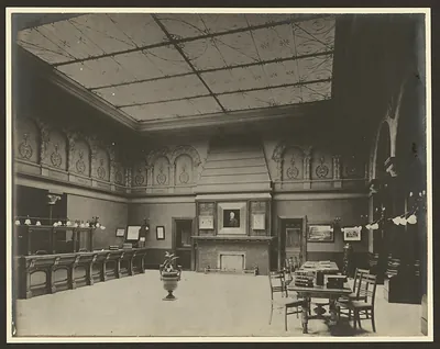Interior of a library with ornate ceiling and fireplace