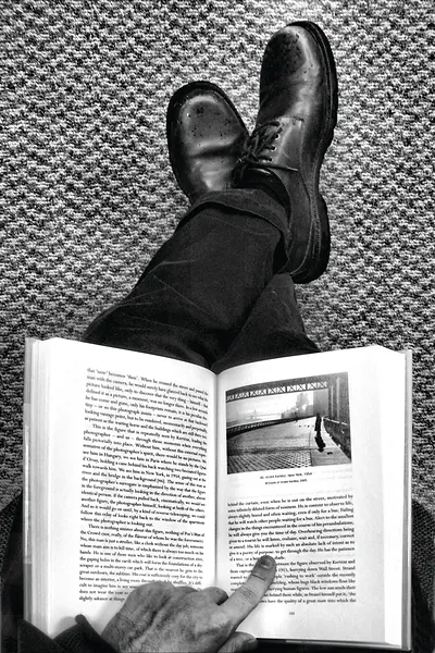 Feet on carpet while reading a book about photography