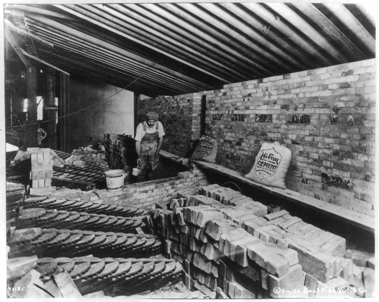 [Man laying bricks inside building], c1922 Nov. 29. — historic photograph