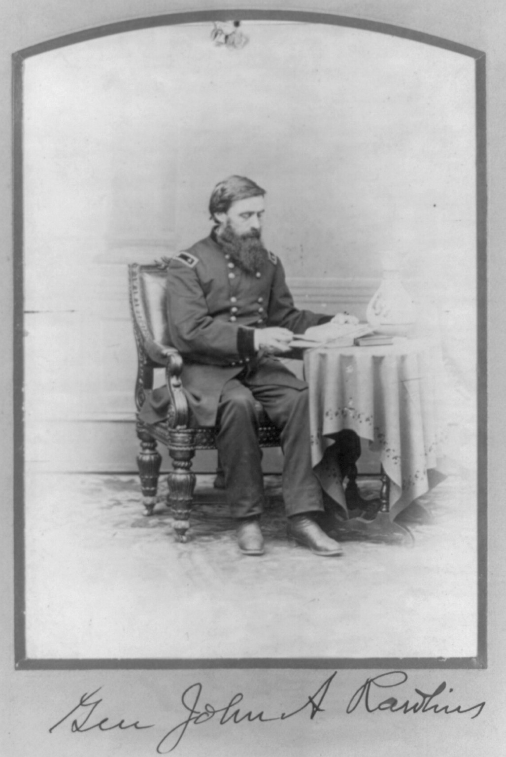 [John Aaron Rawlins, 1831-1869, full length, seated, facing right; at table reading; General] — historic photograph