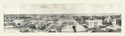 Panoramic photograph of a city with domed building and bay