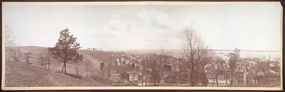 Panoramic sepia photograph of hillside town overlooking bay