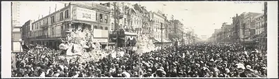 Carnival parade float and dense crowd on city street