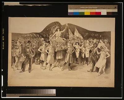 [Woman draped in flag carried by women in Roman costume, surrounded by crowds]