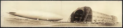 Airship beside large hangar, panoramic photograph