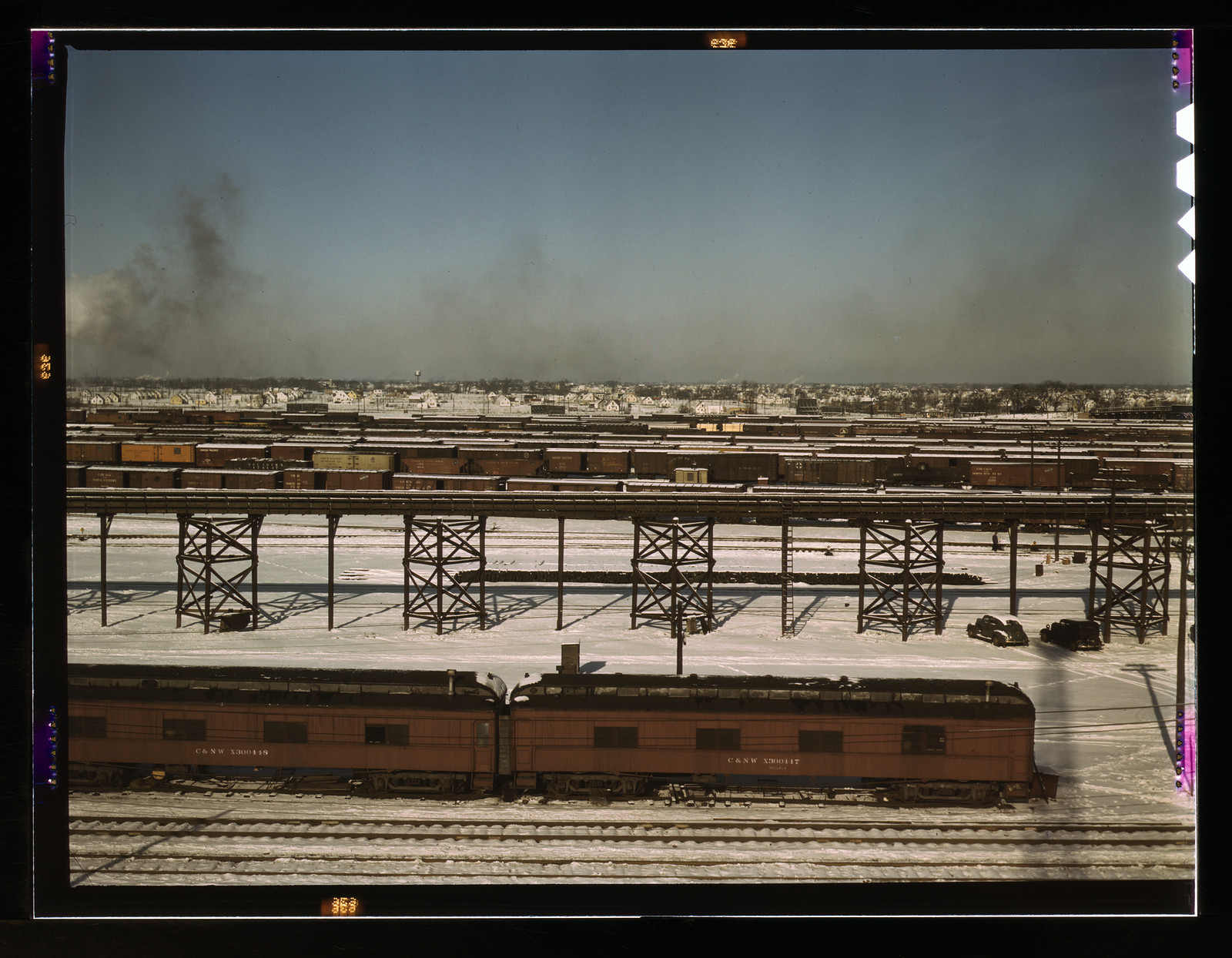 Snowy rail yard with passenger cars and steel trestles — historic image