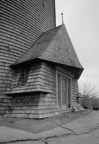Shingled building with bay window and spire finial, black and white photograph