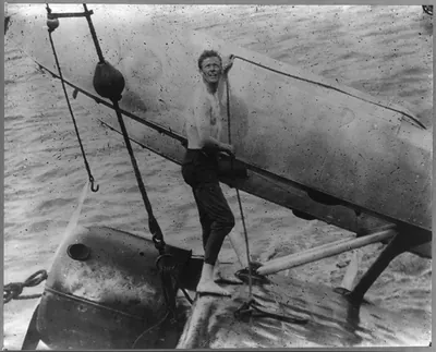 [Lindbergh on damaged left wing of airplane after accident at Hankow, China, Oct. 3, 1931]
