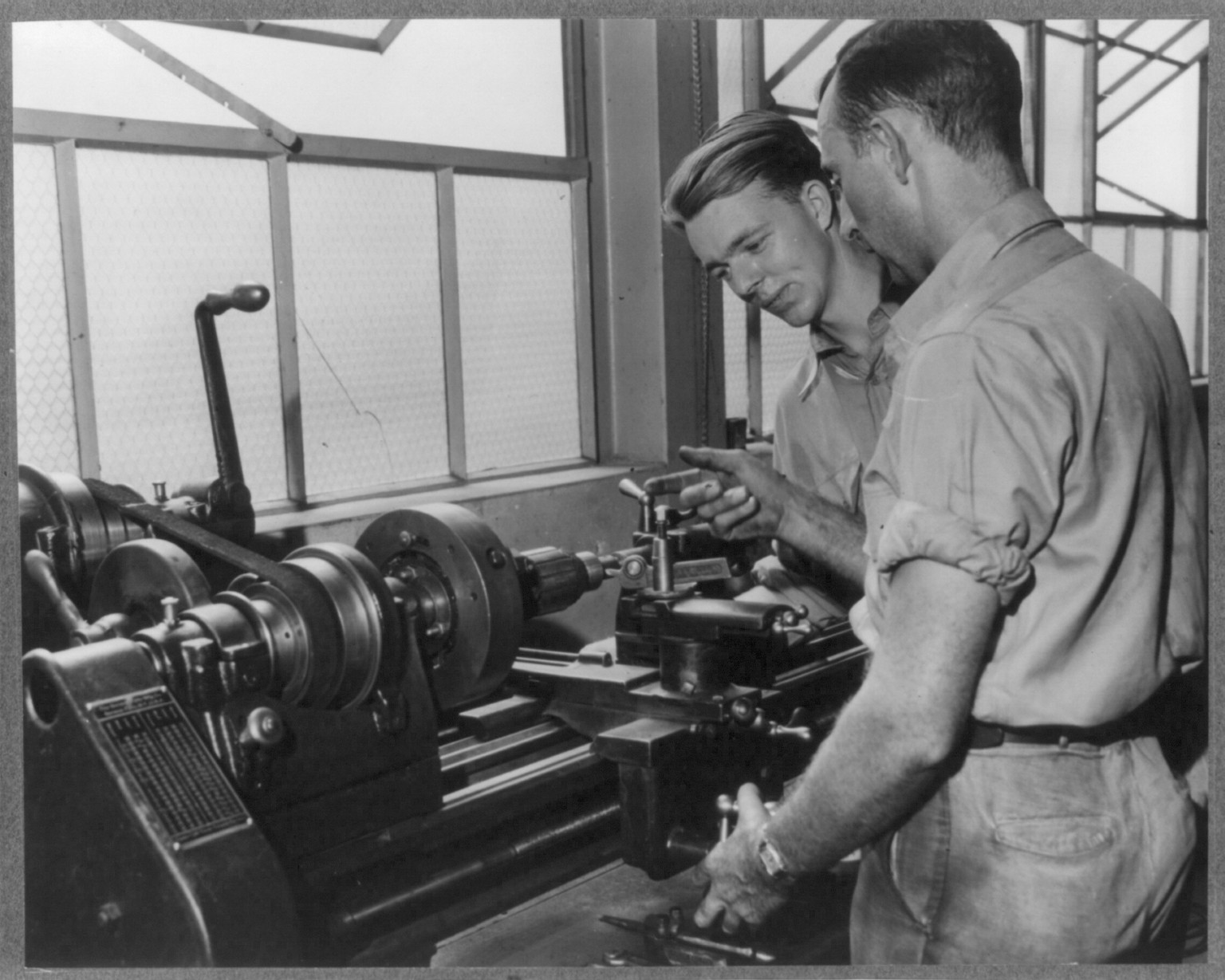 Central Automotive Repair Shop, Salem, Virginia. July 27, 1940. E.E. Williams in charge of the electrical and fuel system department instructs Thomas L. Pulley of Victoria, Virginia in the method of undercutting an armature commutator on a steel turning lathe which is especially equipped for this electrical department — historic photograph