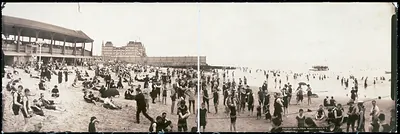 Panoramic beach scene with bathers and seaside pavilion