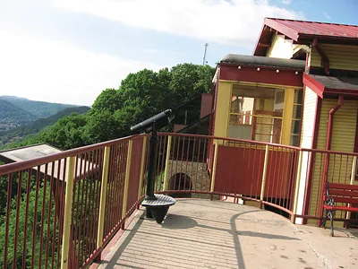 Hilltop viewing platform with coin telescope beside yellow station building