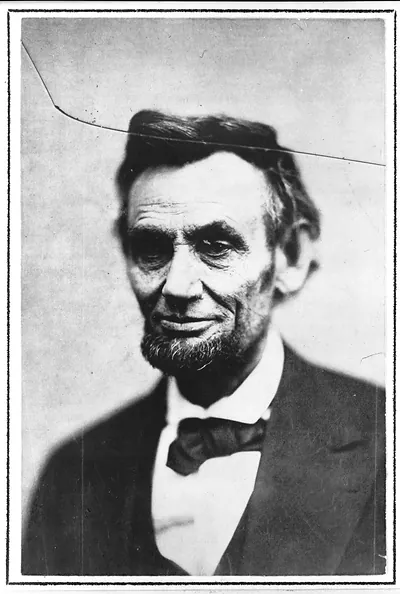 Black and white portrait of a bearded man in suit and bow tie