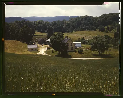 Farmhouse, barns and wheat field in rolling hills