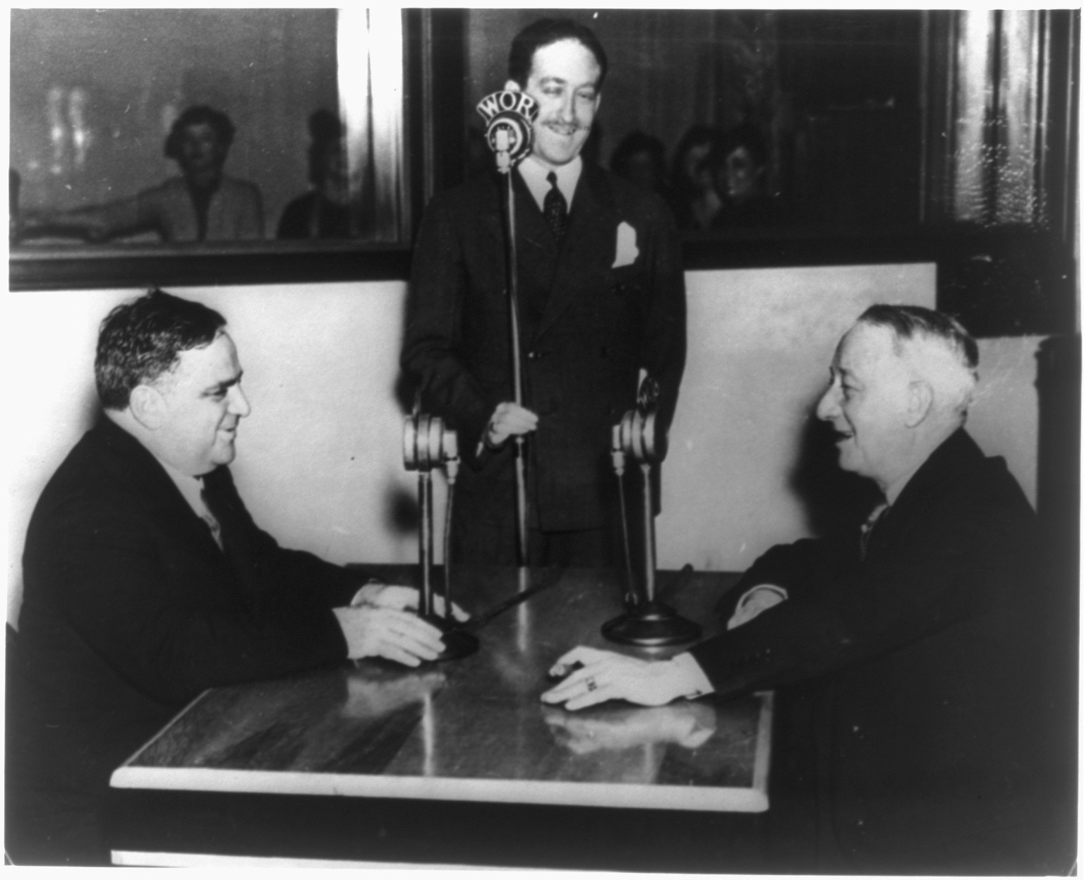 [F.H. La Guardia, Mayor of the City of New York, Theodore Granik, and Al Smith, Governor of New York state at WOR microphones], 1933 — historic photograph