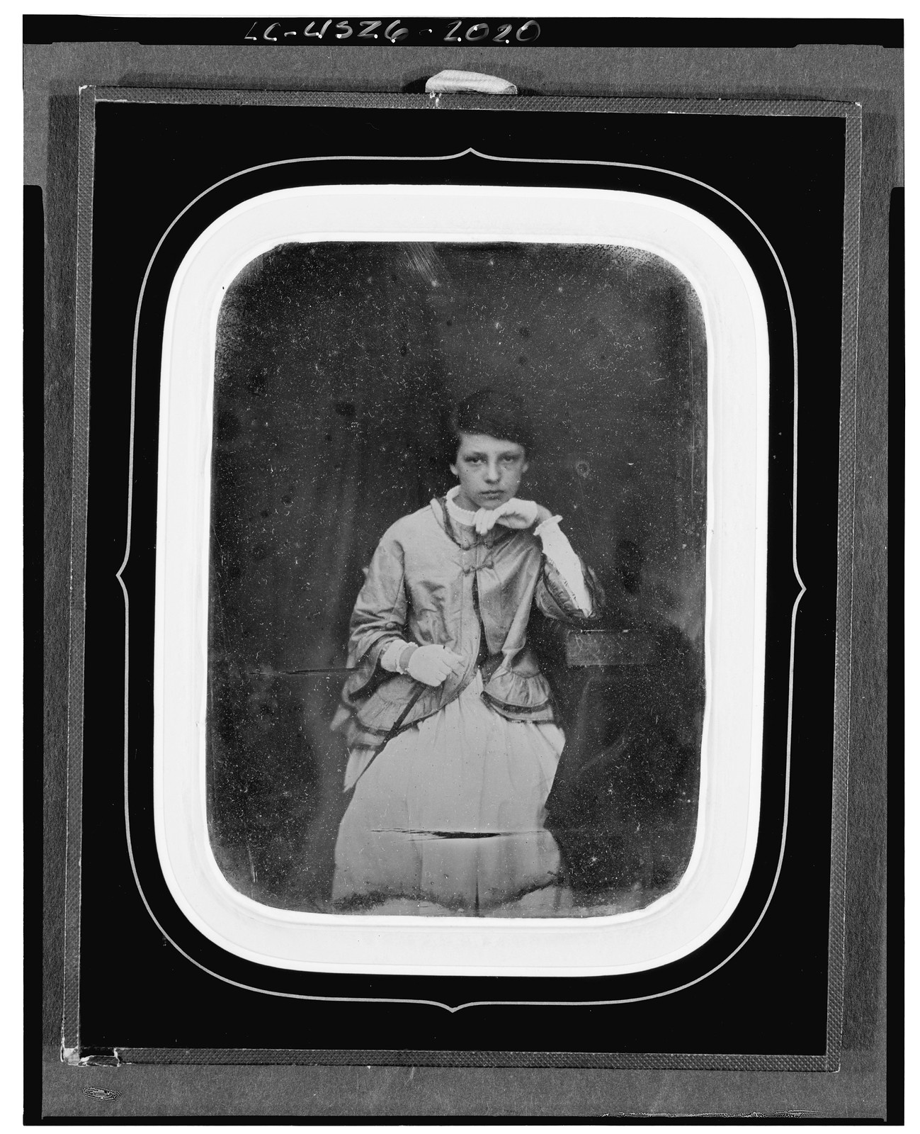 [Unidentified girl, three-quarter length portrait, facing front, seated with elbow on large book on table], [between 1840 and 1860] — historic photograph