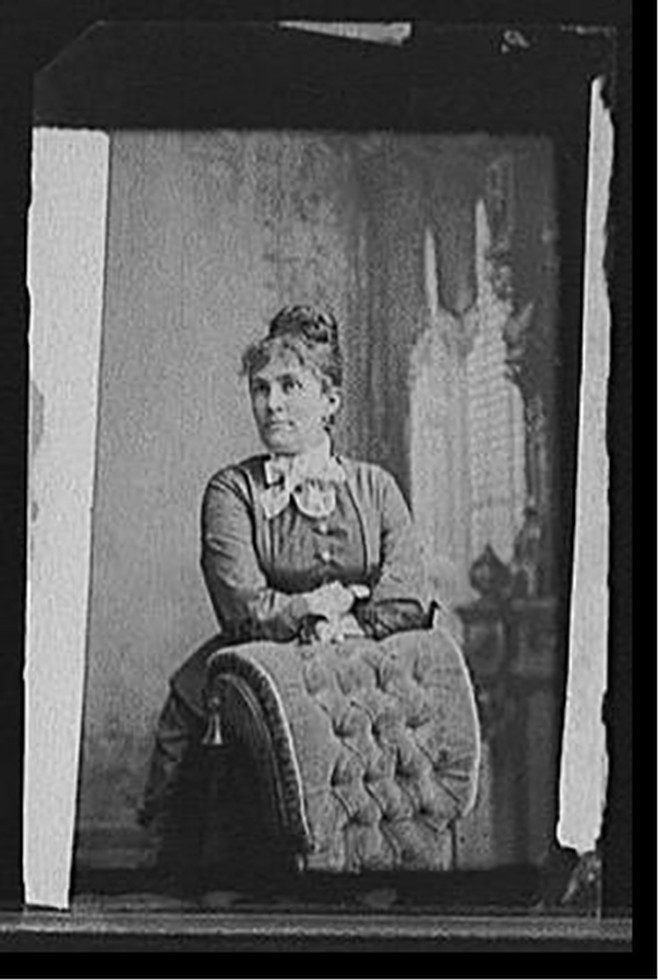 [Emilie Painter Jackson, three-quarter-length portrait posed against chair], [between 1880 and 1910] — historic photograph