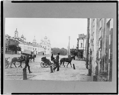 [People and horse-drawn carriages on street, Yaroslavl, Russia]