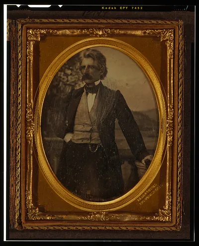 [Unidentified man, three-quarters length portrait, standing in front of painted backdrop]