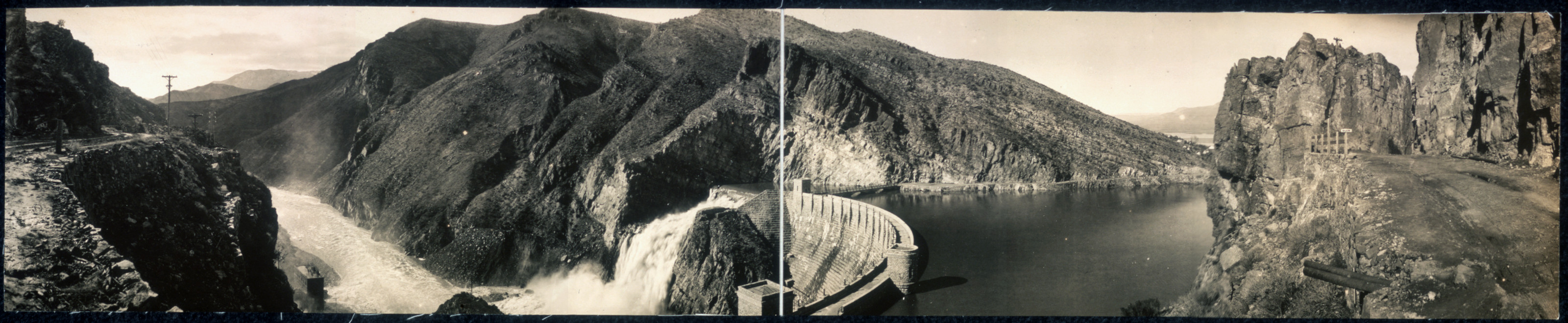 Dam with high water spilling over a canyon reservoir — historic image