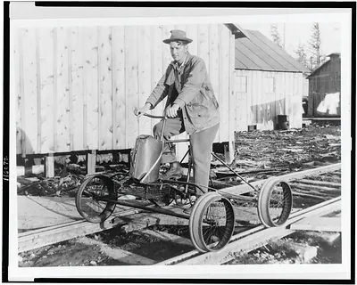 One-man railroad train--Washington man, tired of walking to town, turns his bike and four papier mache wheels into a pedal-locomotive