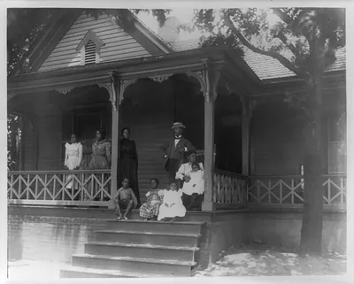 [Home of an African American lawyer, Atlanta, Georgia, with men, women, and children posed on porch of house]