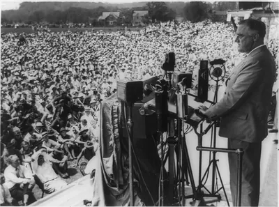 [Franklin Delano Roosevelt, three-quarter length portrait, standing, facing left, making speech to crowd outside]