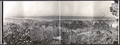 Panoramic photograph of a town overlooking a river and hills
