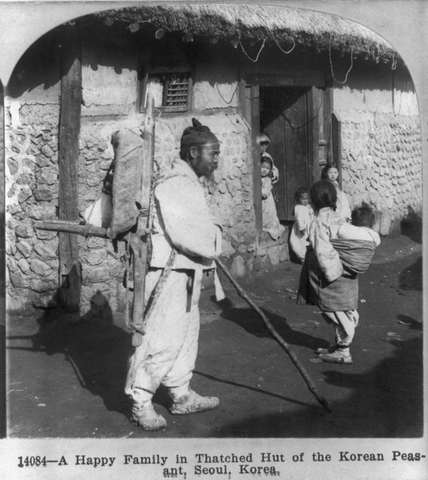 A happy family in thatched hut of the Korean peasant, Seoul, Korea, c1901. — historic photograph