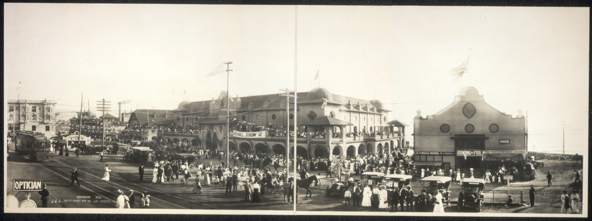 Panoramic view of a seaside resort with crowds and trolleys — historic image