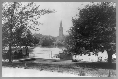 Park lake with church spire and lakeside pavilion, photographed by Clinton Johnson