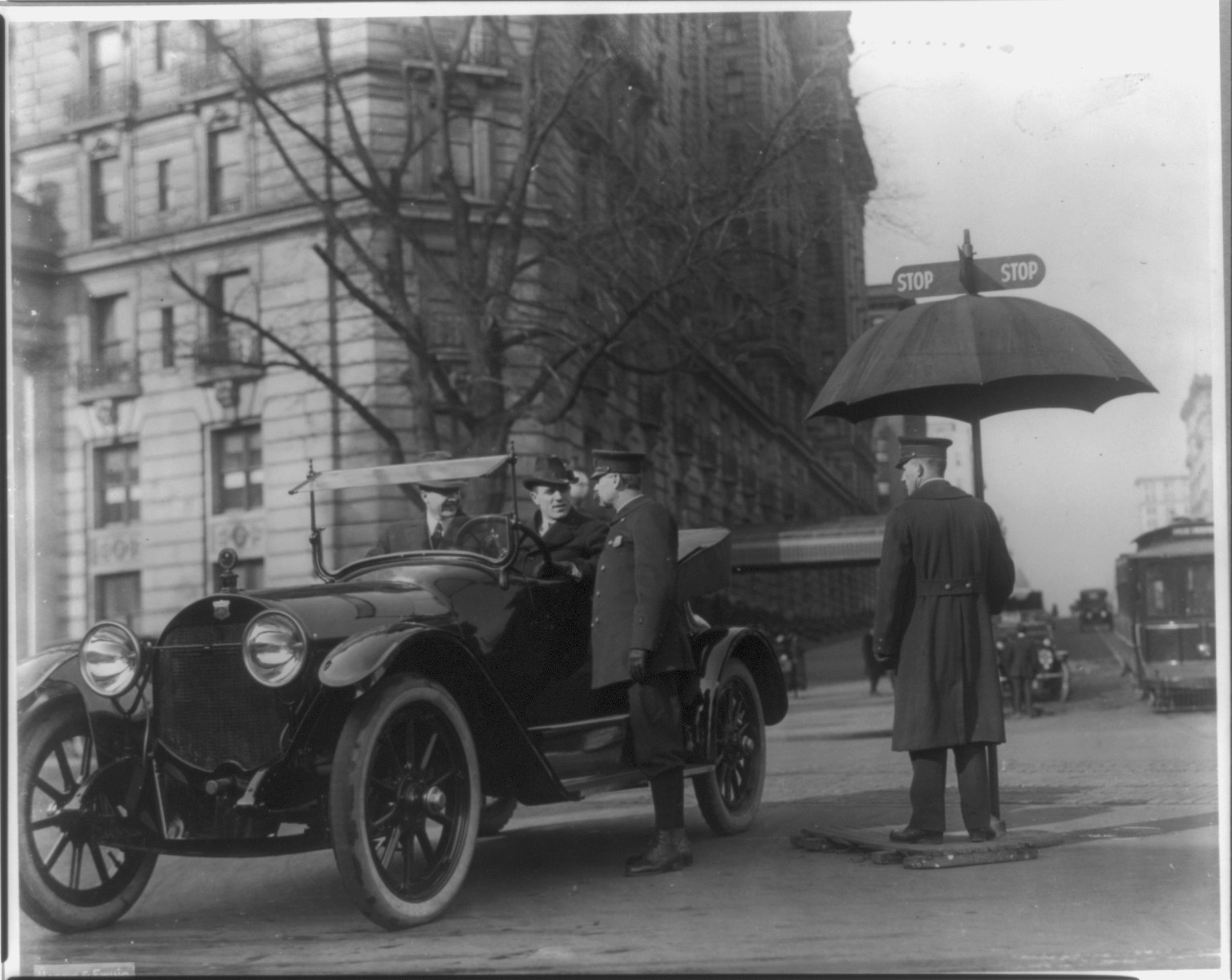 [D.C. - Wash. - 2 men in Haynes auto coupe talking to Traffic policeman at intersection of 14th & Penna. Ave.; Willard Hotel in background] — historic photograph