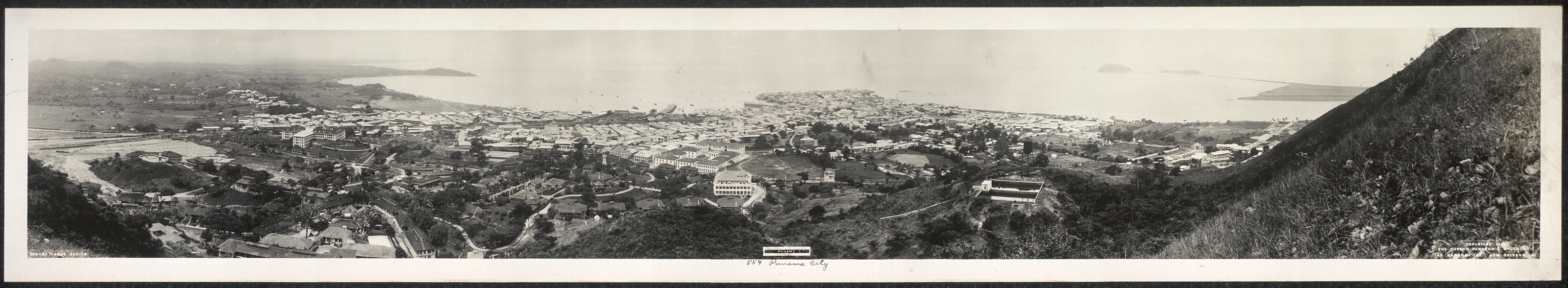 Panoramic photograph of a coastal city from a hillside — historic photograph