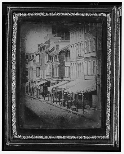 Daguerreotype of a city street with shop awnings