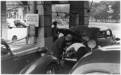 [U.S. Customs and Immigrations officers searching the trunk of automobile for illegal drugs]
