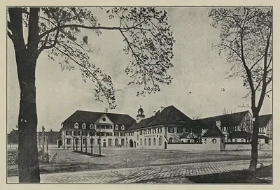 Historic building complex with tower and cobbled square