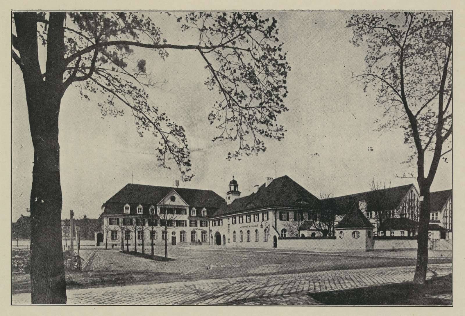 Historic building complex with tower and cobbled square — historic image