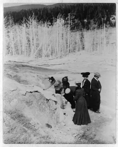 [A group of tourists explore land formations in Yellowstone National Park]
