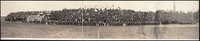 Massed uniformed men on a field, panoramic photograph
