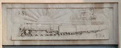 Stone bas relief of steam trains with 1831 and 1936