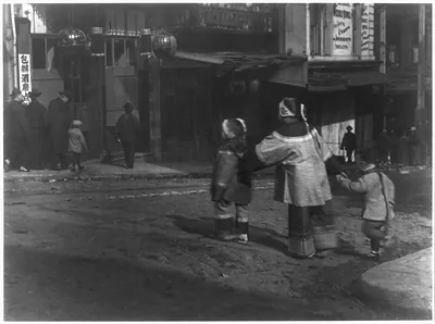 [Chinese in Chinatown, San Francisco: 3 children crossing street holding hands]