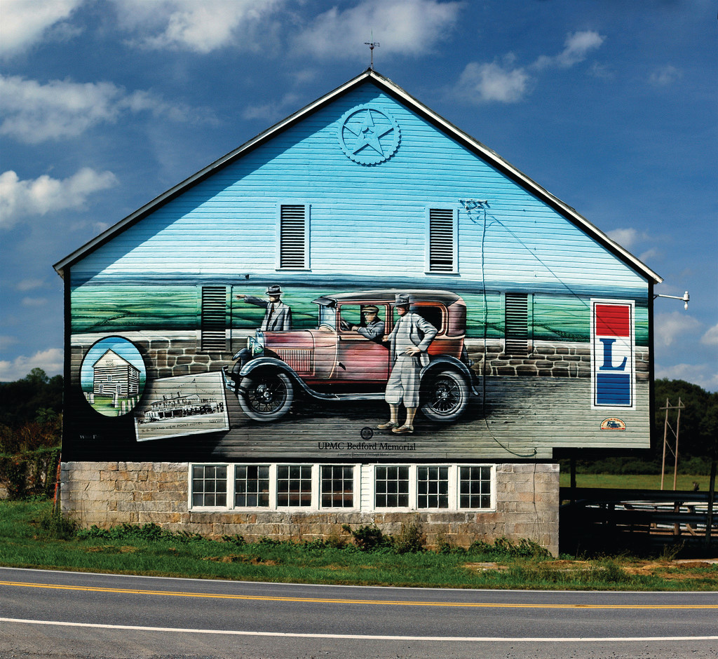 Painted barn mural with vintage car and two figures — historic image