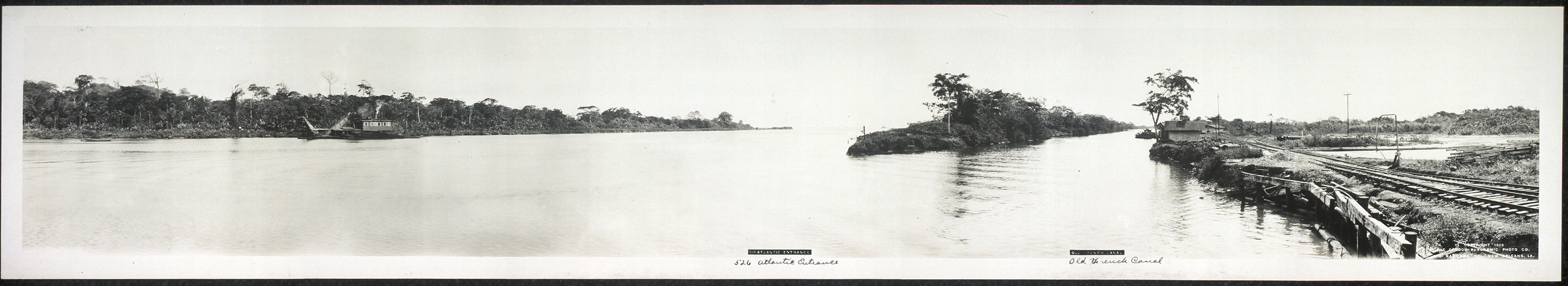 Panoramic black-and-white view of a canal waterway with railway tracks — historic image