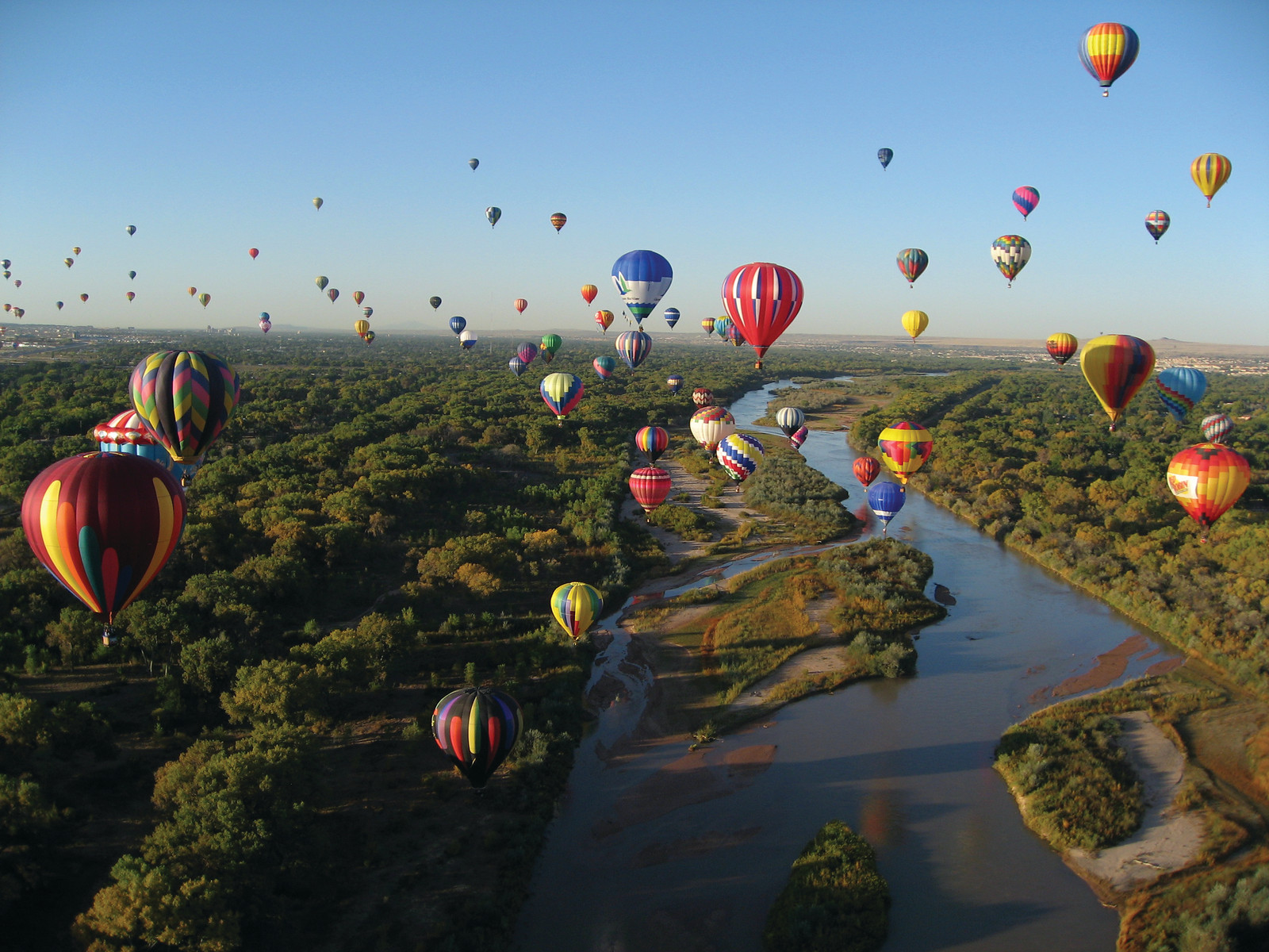 Hot air balloons over a river and cottonwood forest — historic image