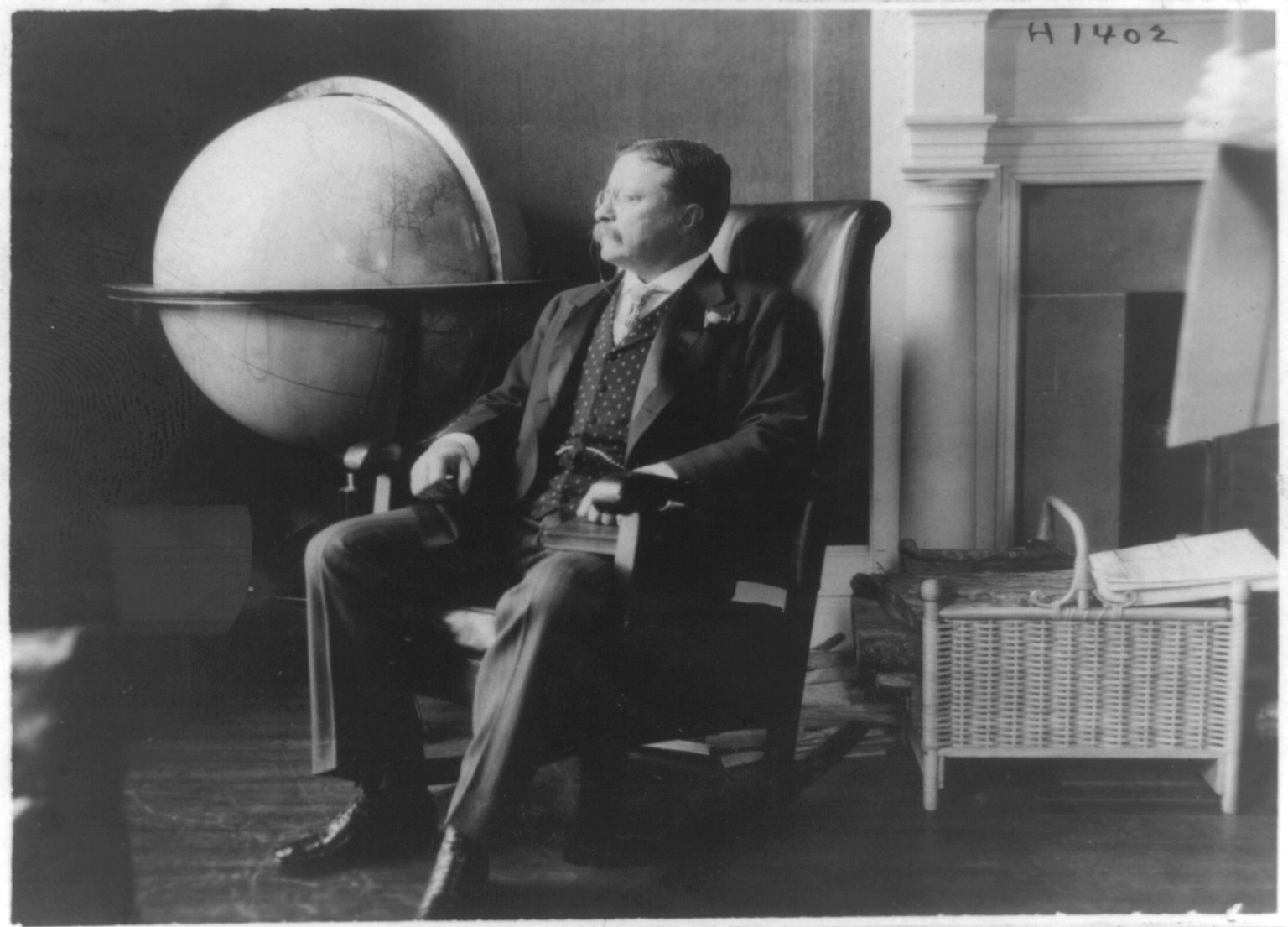 [Theodore Roosevelt, full-length portrait, seated by world globe, facing left], c1905. — historic photograph